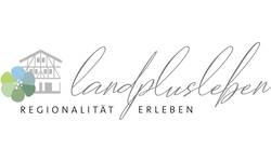 Das Bild zeigt ein Logo mit einem stilisierten Fachwerkhaus und einer Blume links, daneben in eleganter Schrift der Schriftzug "landplusleben" und darunter in Großbuchstaben die Worte "REGIONALITÄT ERLEBEN".